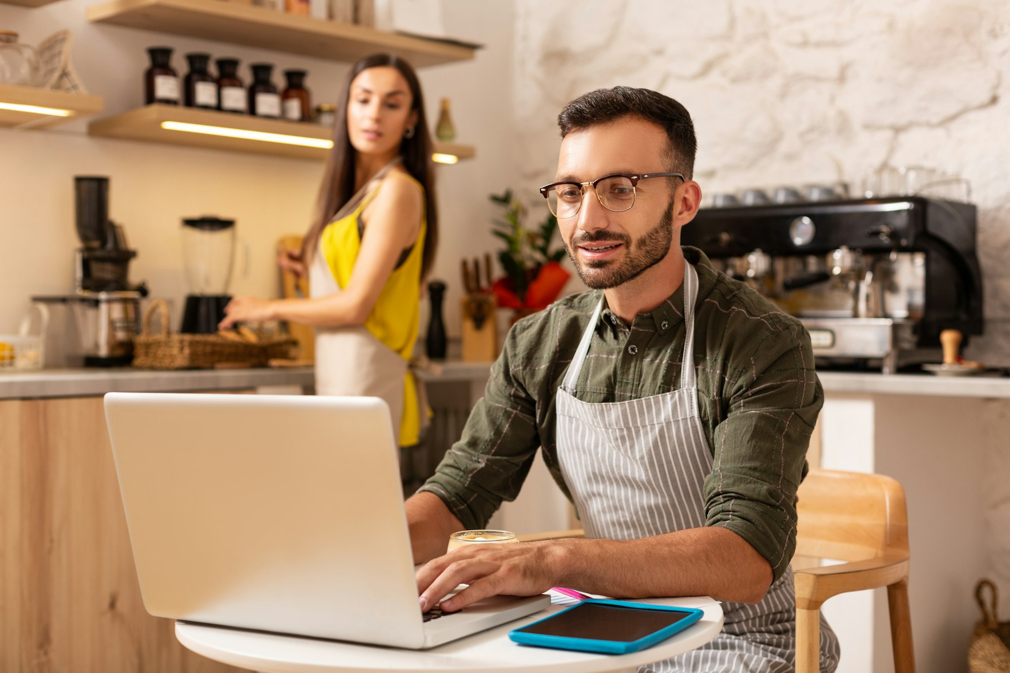 Husband working on laptop while owning family business