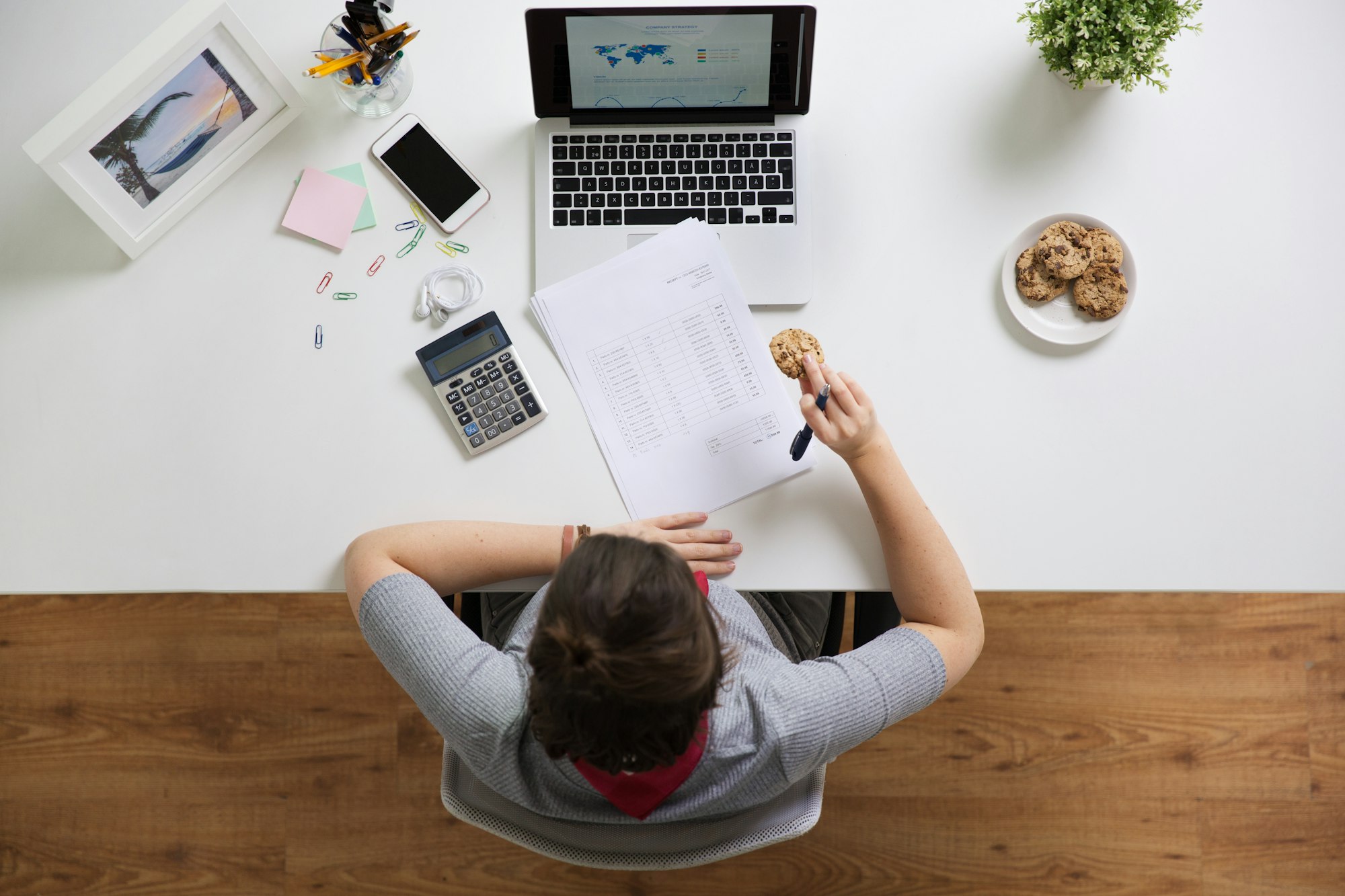 woman with tax report eating cookie at office